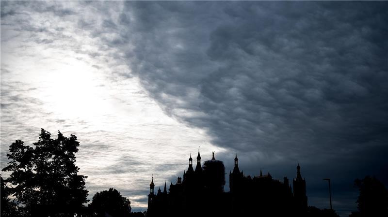 Bilder des Tages Düstere Kulisse: Dunkle Wolken ziehen über das Schweriner Schloss.