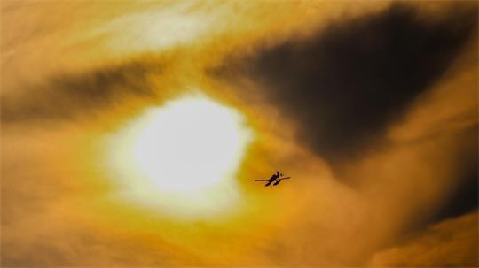Durch dunkle Rauchschwaden: Ein schwedisches Löschflugzeug fliegt über dem Brandgebiet im Hohen Venn.