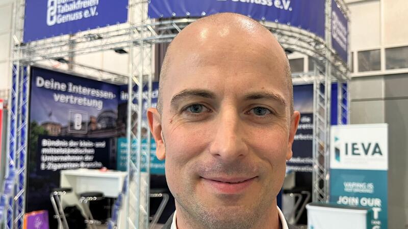 Bundesbürger geben mehr Geld für E-Zigaretten aus Dustin Dahlmann, Vorsitzender des E-Zigaretten-Verbandes „Bündnis für Tabakfreien Genuss“ (BfTG), steht bei der Messe Intertabac 2023 vor einem Stand seiner Organisation.
