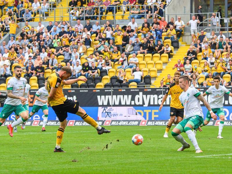 Dynamos Christoph Daferner (l) erzielt gegen Bremens Marco Friedl das Tor zum 1:0. Foto: Robert Michael/dpa-Zentralbild/dpa