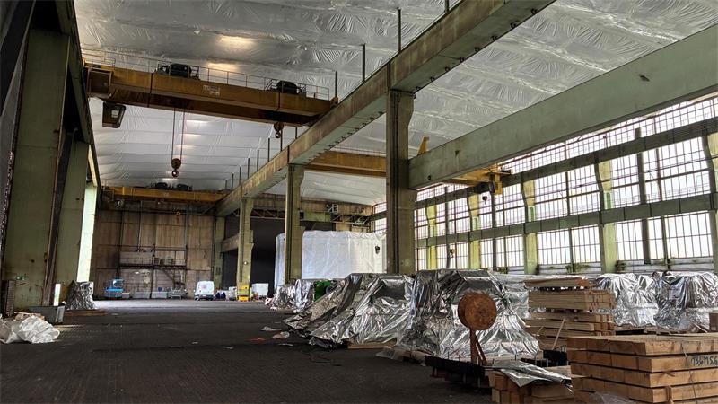 EPS dichtet das marode Hallendach ab: Früher fertigte Sietas hier Sektionen für Schiffe, jetzt warten Industrieanlagen und Motoren auf den Umschlag.