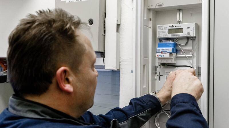 Ein Elektriker montiert einen digitalen Stromzähler. 