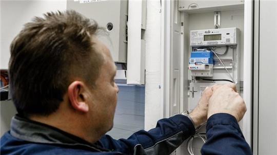 Ein Elektriker montiert einen digitalen Stromzähler. 