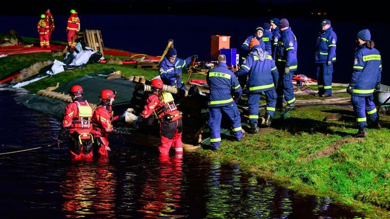 Dauereinsatz in den Hochwassergebieten Ehrenamtliche Einsatzkräfte vom THW und der DLRG befestigen einen Deich in Niedersachsen.