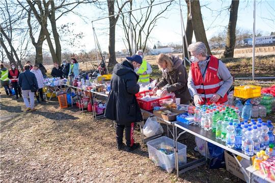 Ehrenamtliche Helfer der Initiative "Meiendorf hilft" haben Anfang März nahe der Zentralen Erstaufnahmestelle (ZEA) in Rahlstedt Tische mit Lebensmitteln, Hygiene-Produkten und weiterem Material aufgebaut. Foto: Jonas Walzberg/dpa