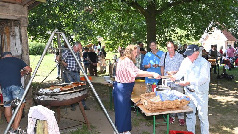 Ehrenamtliche des Vereins stehen am Grill.