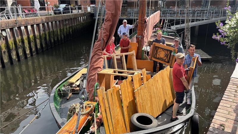 Ehrenamtliche räumen den Frachtraum des Ewers Margareta aus.
