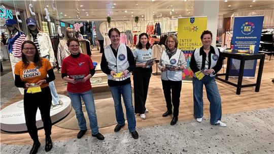Ehrenamtliche vom Bündnis Buxtehude empfangen im Modehaus Stackmann Kundinnen und Kunden mit Programmheften zu den Internationalen Wochen gegen Rassismus.