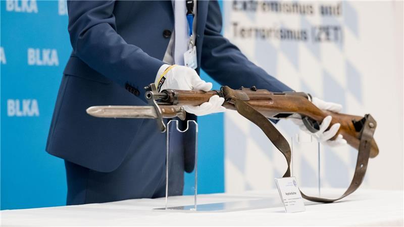 Ein 18 Jahre alter Österreicher hatte am 5. September 2024 mit einem Repetiergewehr aus ehemaligen Schweizer Armee-Beständen auf das Konsulat in der bayerischen Landeshauptstadt geschossen sowie auf das NS-Dokumentationszentrum in der Nähe. Er starb nach einem Schusswechsel mit Polizisten. Ein Polizeibeamter zeigt bei einer Pressekonferenz die Tatwaffe, eine Repetierbüchse aus Schweizer Fertigung (Karabiner 31). Ermittler werten die Schüsse auf das Generalkonsulat als antiisraelischen Terroranschlag. (Archivfoto)