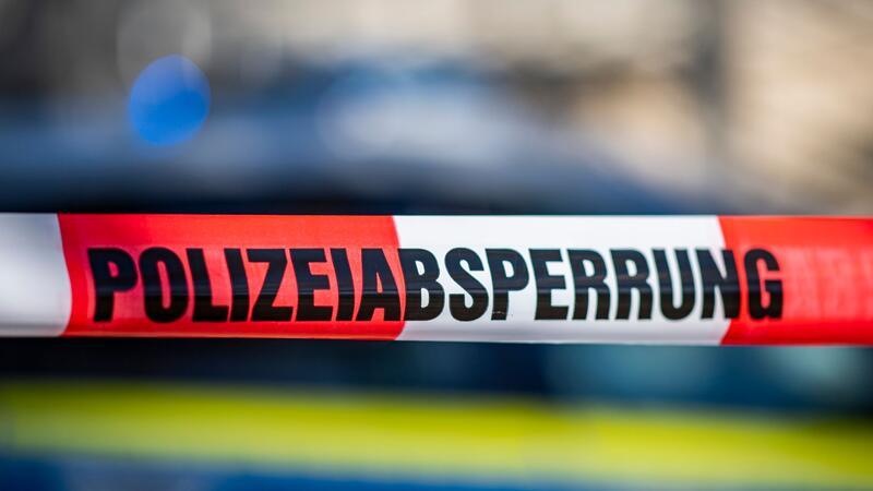 34-Jähriger bei Messerangriff lebensgefährlich verletzt Ein Absperrband der Polizei ist vor einem Streifenwagen aufgespannt.