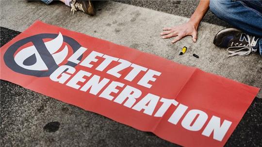 Ein Aktivist der Letzten Generation klebt seine Hand auf einer Straße fest. Solche Klebeaktionen hat die Gruppe inzwischen aufgegeben - und nun eine Kandidatur für das Europaparlament angekündigt (Archivbild).
