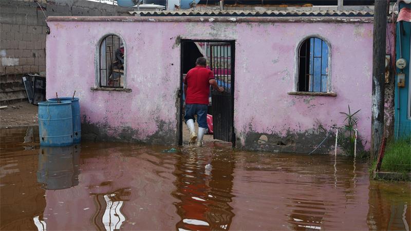 Ein Anwohner betritt sein Haus, das nach dem Durchzug vom Hurrikan „Polo“ in Puerto San Carlos in Mexiko im Wasser steht.