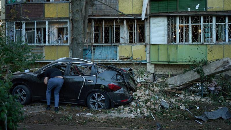Ein Anwohner blickt nach einem nächtlichen russischen Angriff in ein zerstörtes Auto.
