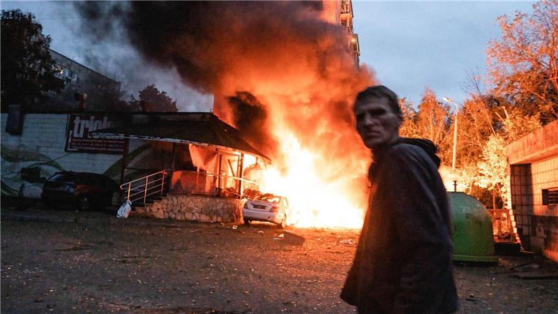 Bilder des Tages Ein Anwohner geht nach einem Luftangriff in Kiew an einem Feuer vorbei.