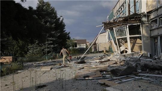Ein Anwohner läuft eine beschädigte Straße entlang, dem Schauplatz schwerer Kämpfe mit russischen Truppen in der Region Donezk. 