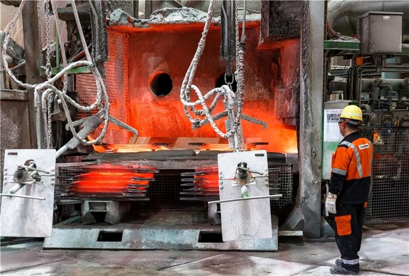 Ein Arbeiter steht vor einem Anodenofen, der zum Start einer Versuchsreihe erstmalig mit grünem Wasserstoff und Stickstoff statt Erdgas betrieben wurde, um so den CO 2 -Ausstoß in der Kupferproduktion zu senken. Foto: Scholz/dpa