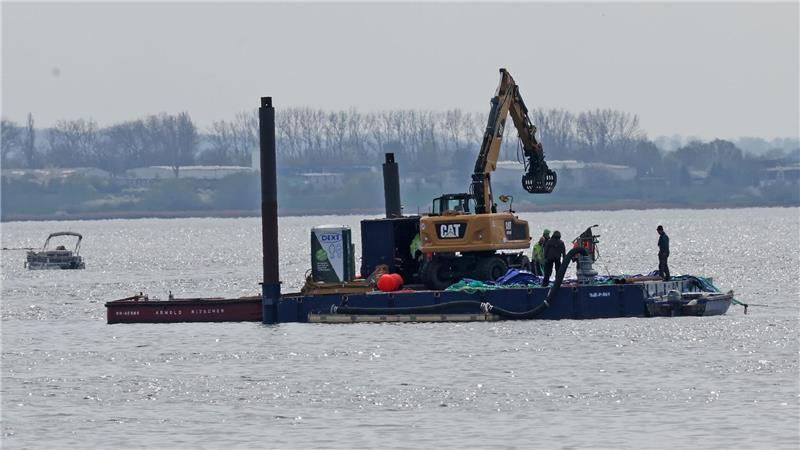 Ein Arbeitsponton mit einem speziellen Bagger und kleinere Begleitboote sind in der Nähe des gestrandeten Buckelwals vor der Insel Poel im Einsatz. 