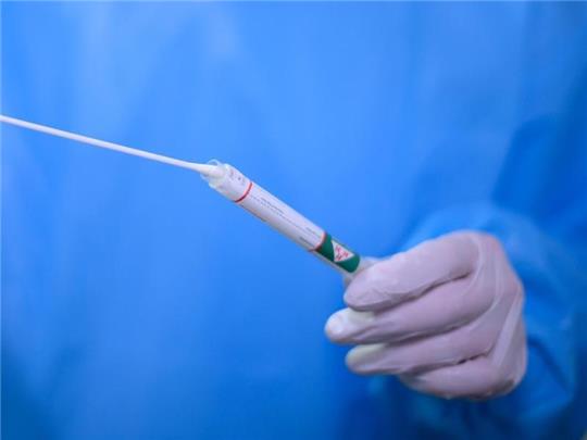 Ein Arzt hält einen Coronavirus-Test in den Händen. Foto: Robert Michael/dpa-Zentralbild/dpa/Symbolbild