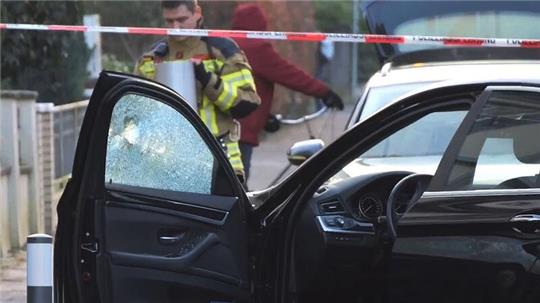 Ein Auto, an dem die Fensterscheibe ein Loch hat, wird untersucht.