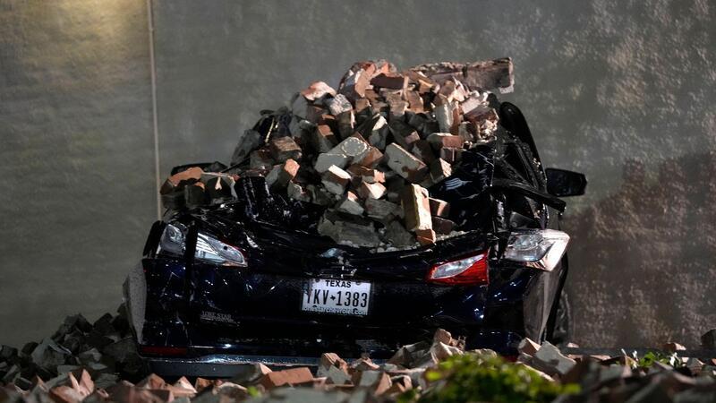 Ein Auto, das von herabfallenden Ziegeln einer umgestürzten Hauswand zerquetscht wurde, steht auf einem Parkplatz in der Innenstadt von Houston.