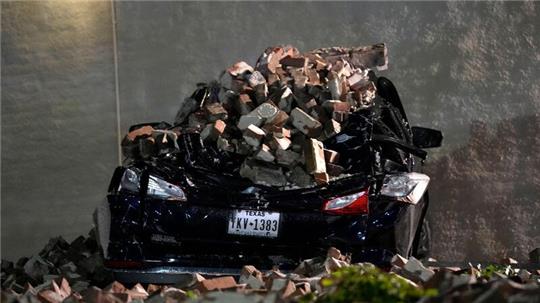 Ein Auto, das von herabfallenden Ziegeln einer umgestürzten Hauswand zerquetscht wurde, steht auf einem Parkplatz in der Innenstadt von Houston.