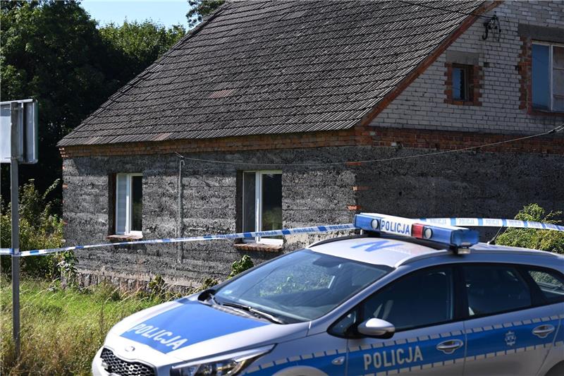 Ein Auto der Polizei steht während Ermittlungsarbeiten vor einem Familienhaus.