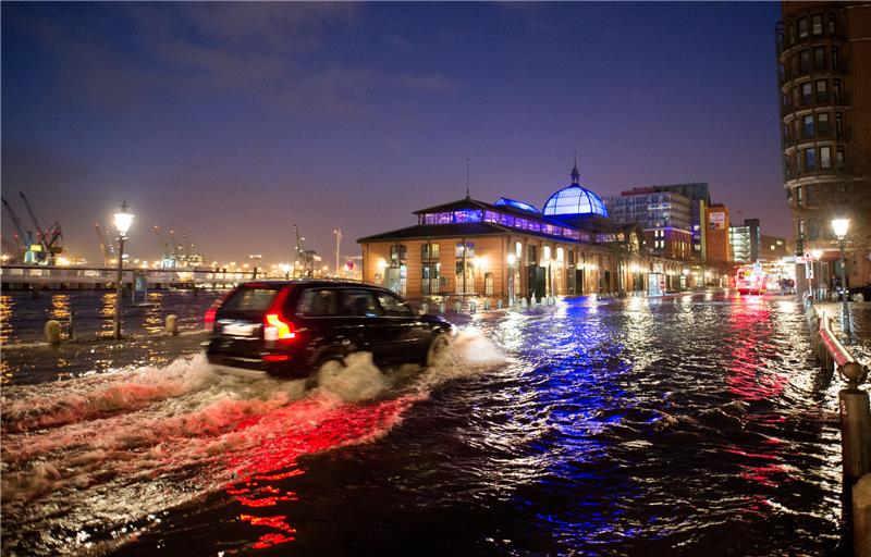 Ein Auto fährt am 04.01.2017 in Hamburg während einer Sturmflut über den überfluteten Fischmarkt vor der Fischauktionshalle. Foto: Archiv dpa