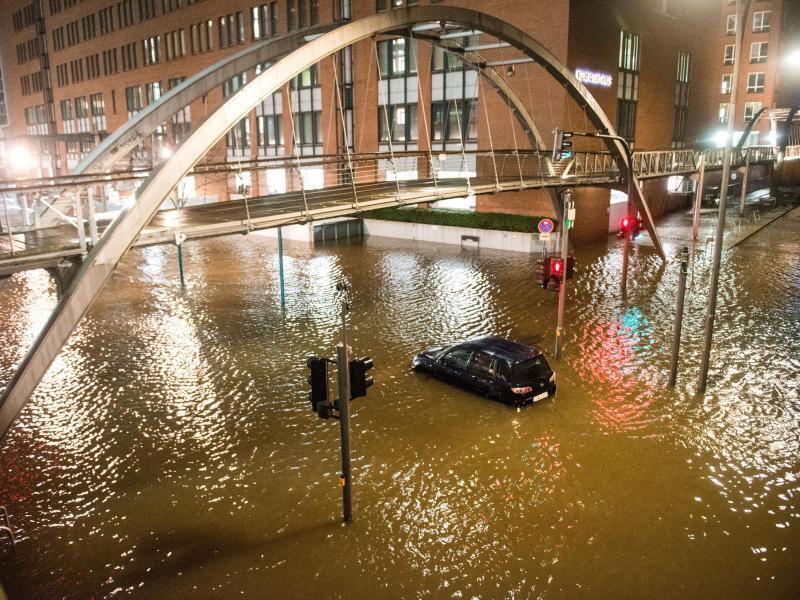 Ein Auto ist in der Hamburger Speicherstadt im Hochwasser eingeschlossen. Foto: Daniel Bockwoldt/dpa
