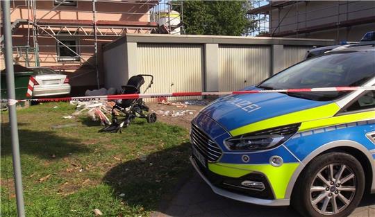 Ein Auto (links hinten) steht an einem Haus, nachdem der Fahrer zuvor eine Frau und ein Kind angefahren und lebensgefährlich verletzt hatte.