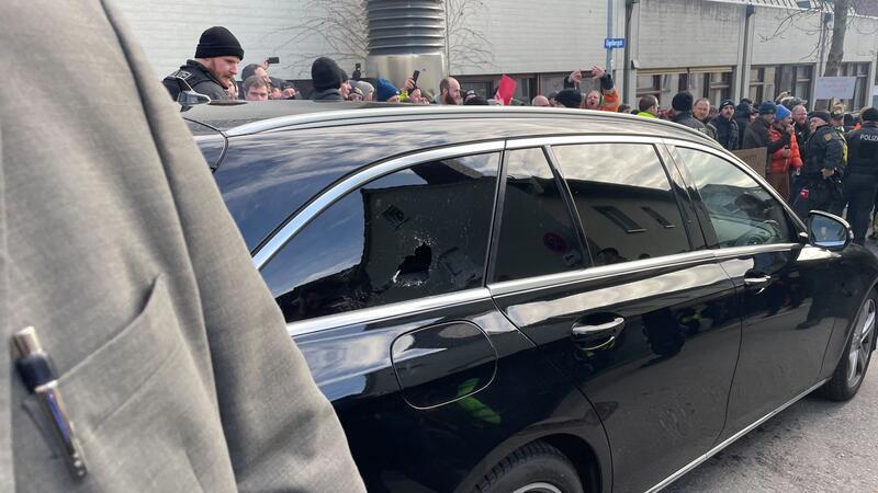 Ein Auto mit eingeschlagener Scheibe vor der Veranstaltungshalle.