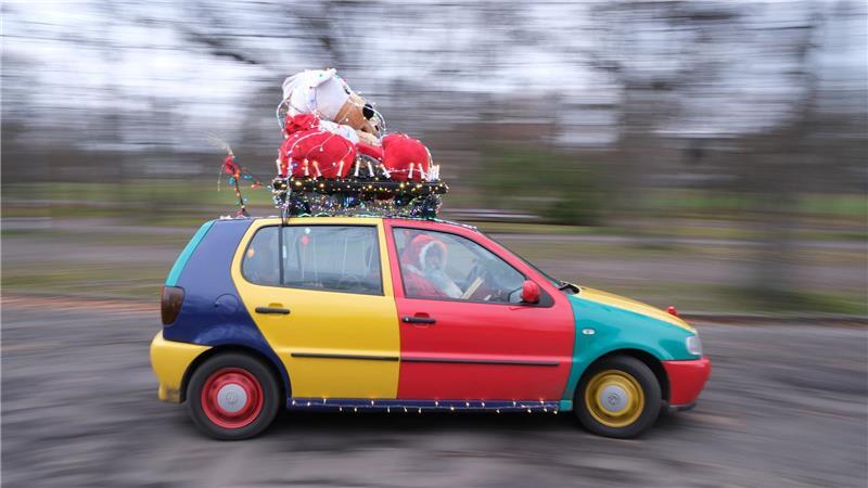 Ein Auto vom Typ Volkswagen Polo in der Edition Harlekin aus dem Jahr 1996 fährt weihnachtlich dekoriert durch Leipzig. 
