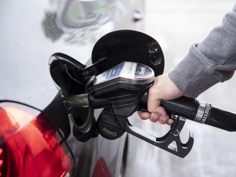 Ein Autofahrer steckt an einer Tankstelle einen Zapfhahn in die Tanköffnung seines Fahrzeugs. Für Kraftstoffe und Heizöl mussten Verbraucher zuletzt deutlich tiefer in die Tasche greifen als ein Jahr zuvor. Foto: Felix König/dpa