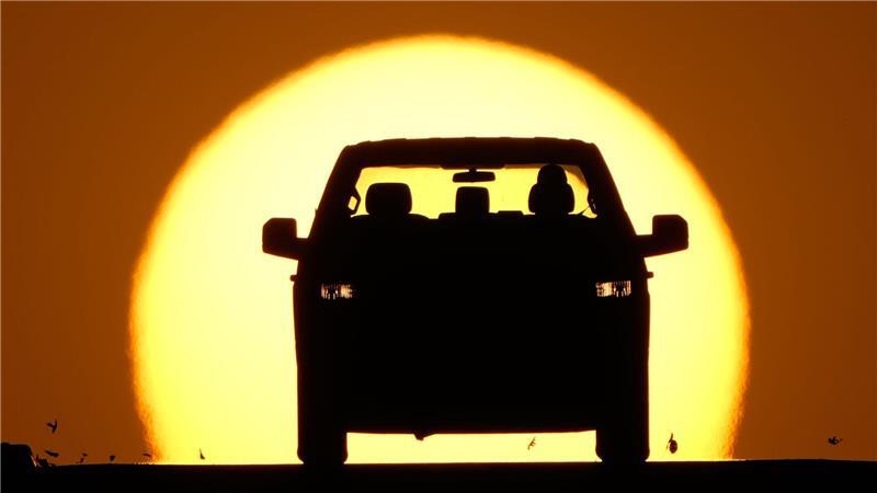 Ein Autofahrer wird von der untergehenden Sonne angestrahlt.