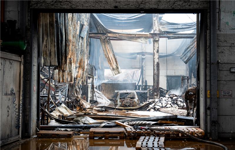 Drei Tage nach Großbrand weiter Löscharbeiten in Rothenburgsort Ein Autowrack und Brandschutt stehen und liegen im Stadtteil Rothenburgsort in den Resten einer abgebrannten Lagerhalle. Foto: Bockwoldt/dpa