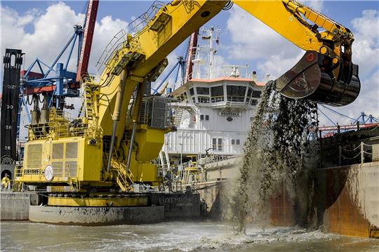 Ein Bagger holt bei Arbeiten zur Elbvertiefung Schlick aus einem Hafenbecken. Foto: Axel Heimken/dpa