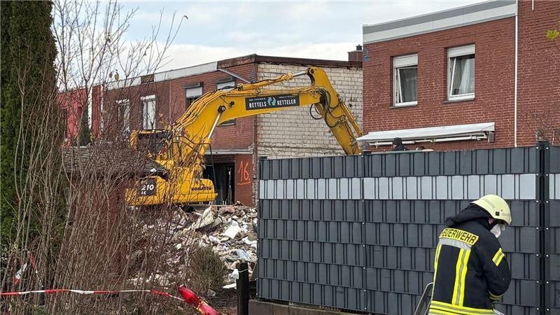 Ein Bagger räumt den Schutt eines eingestürzten Reihenhauses in Wolfenbüttel fort. In den Trümmern ist eine Leiche entdeckt worden. 