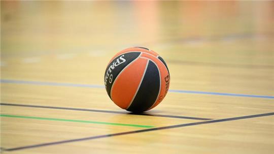 Ein Ball liegt auf einem Basketball-Spielfeld.