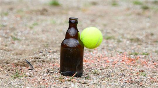 Ein Ball trifft während einer Partie die Bierflasche im Spielfeld.