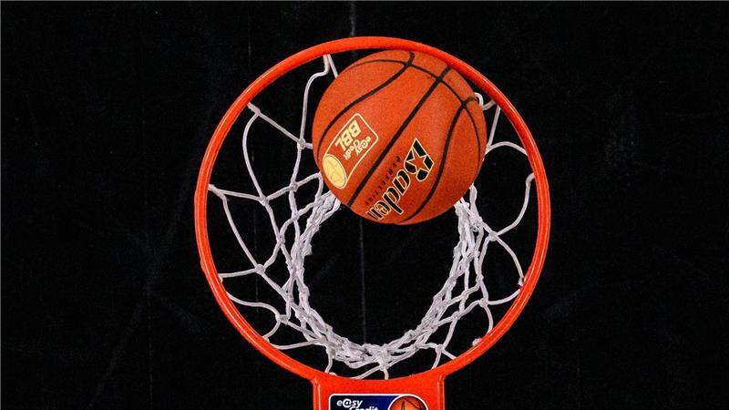 Ein Basketball fällt in einen Basketballkorb.