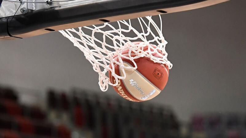 Ein Basketball landet im Korb.