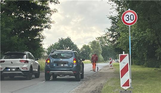 Ein Bauarbeiter misst die Schadstellen am Hagener Weg in Dollern mit dem Hodometer ab - und markiert die Bereiche mit Farbe.