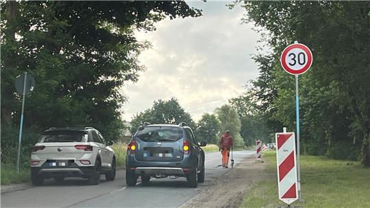 Ein Bauarbeiter misst die Schadstellen am Hagener Weg in Dollern mit dem Hodometer ab - und markiert die Bereiche mit Farbe.
