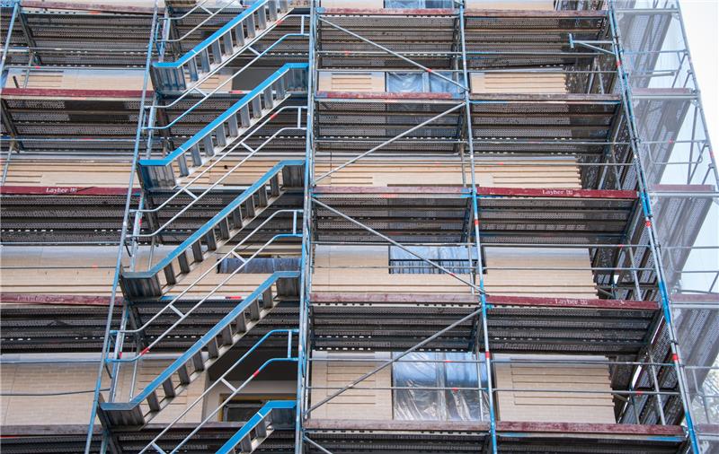 Ein Baugerüst steht an einem Haus-Neubau mit Wohnungen. Foto: Daniel Bockwoldt/dpa