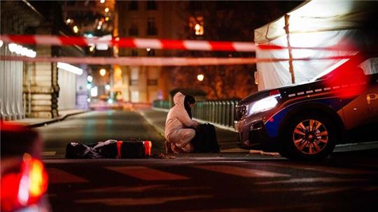 Ein Beamter der Kriminalpolizei arbeitet am Tatort unweit des Eiffelturms in Paris.