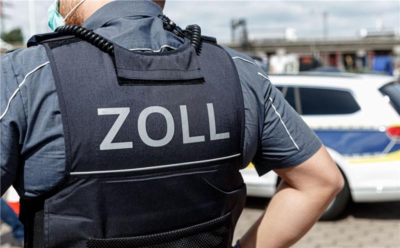 Fund im Container: Mehr als 1000 Patronen unter Textilien versteckt Ein Beamter trägt während seines Dienstes eine Schutzweste mit der Rückenaufschrift "Zoll".