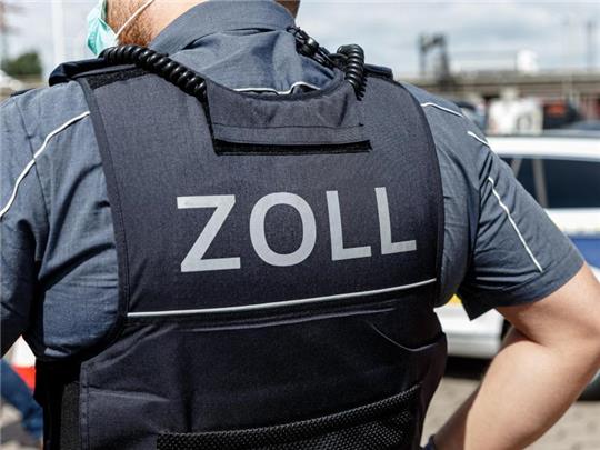 Ein Beamter trägt während seines Dienstes eine Schutzweste mit der Rückenaufschrift "Zoll". Foto: Markus Scholz/dpa/Symbolbild
