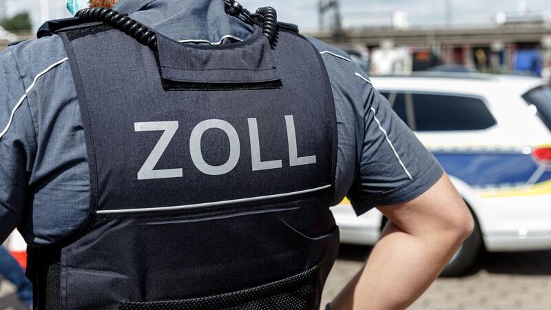 Zoll: 84 illegal Beschäftigte in Lebensmittelbetrieb Ein Beamter trägt während seines Dienstes eine Schutzweste mit der Rückenaufschrift „Zoll“.