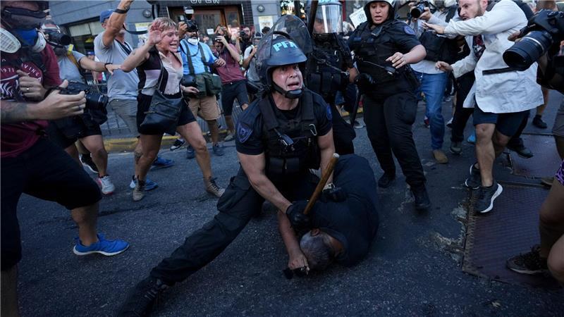 Ein Bereitschaftspolizist hält einen Demonstranten während einer Demonstration in Buenos Aires für bessere Renten fest.
