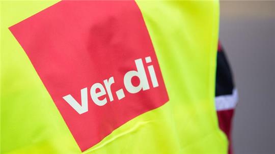 Ein Beschäftigter trägt bei einem Warnstreik eine Warnweste von Verdi.