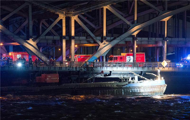 Ein Binnenschiff hängt unter der Freihafenelbbrücke fest. Beim Durchfahren der Brücke im starken Sturm war das Schiff am Sonnabend mit dem Steuerhaus an der Brücke hängengeblieben und hat sich dabei verklemmt. Foto: Daniel Bockwoldt/dpa